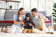 © aekkorn - Happy young asian family mom and dad with daughter having fun in liviing room at home, while daughter using tablet. Family,love and happiness concept.