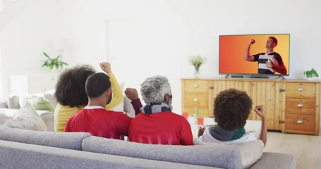 Canvas Print - Biracial family watching tv with caucasian male rugby player with ball on screen