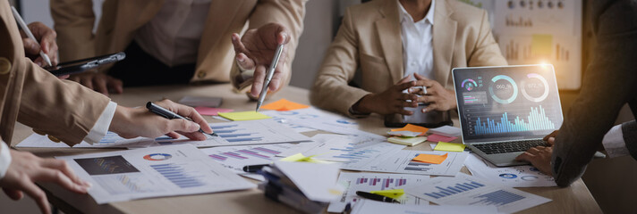 Technology and financial advisory services concept. Business teamwork and working on digital laptop computer with advisor showing plan of investment to clients at table office. Digital marketing.