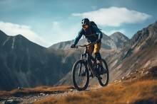The Athletic Man Pedals An MTB E-bike Up A Steep Grassy Hill. Beautiful View Of The Mountains At Sunrise/sunset With Sun Flare. Alone In Nature, Thinking About Life.
