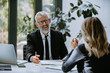 © gstockstudio - Happy mature man in formalwear having business meeting with employee in the modern office