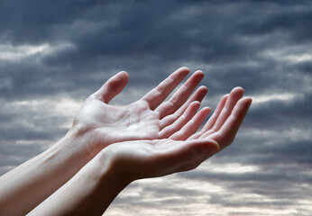 Wall Mural - The outstretched hands of a praying man