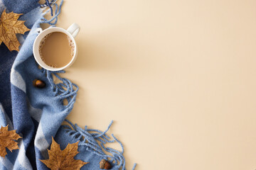 Wall Mural - Embrace the splendor of the fall season at home. Top view photo of cozy blanket, hot cocoa, acorns, dry autumn leaves on pastel beige background with ad placement