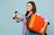 © ViDi Studio - Side view traveler woman wear casual clothes hold suitcase bag isolated on plain pastel blue color background. Tourist travel abroad in free spare time rest getaway. Air flight trip journey concept.