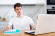 © caftor - Young guy studying at home with laptop