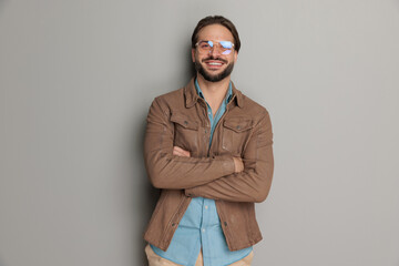 Wall Mural - happy young man with glasses crossing arms and laughing