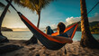 © MP Studio - Happy man lies in a hammock against a backdrop of palm trees and the sea during a vacation