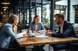 © Simon - A group of businesspeople are sitting around a table and discussing a new project.