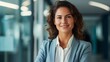 © TAMA KUN - Portrait of smiling businesswoman standing in office corridor. Businesswoman looking at camera.