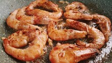 fresh, tiger prawns, frying in a frying pan, fried in oil with garlic and spices, mobile video,