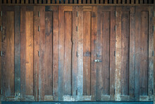 Traditional Antique Wooden Folding Door Asian Style Frame. Thai Traditional Wooden Gate Of Historical Architecture. Beautiful Retro Wooden Folding Door With Lock Under Evening Sunlight. Vintage Door.