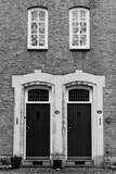 Fototapeta Na ścianę - Black and white version of a historic facade with twin doors and windows entirely in symmetry.