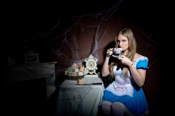 Halloween. Portrait of a young woman with a large kitchen knife. Dressed as Alice