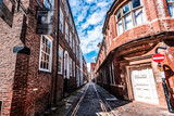 Fototapeta Mosty linowy / wiszący - Narrow street with brick buildings in Hull