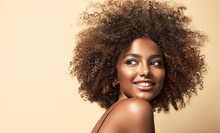 Beautiful Black Woman . Beauty Portrait Of African American Woman With Clean Healthy Skin On Beige Background. Smiling Beautiful Afro Girl.Curly Black Hair .Afro Hairstyle