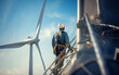 A worker standing on top of a wind turbine with a harness