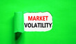 Leinwandbild Motiv Market volatility symbol. Concept words Market volatility on beautiful white paper. Beautiful green paper background. Business market volatility concept. Copy space.orange