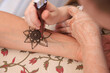 Henna design being applied to a persons arm