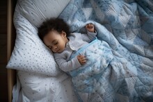 A Sleeping Baby Boy, Peacefully Resting In His Crib With A Soft Blanket, Embodies The Innocence Of Childhood.