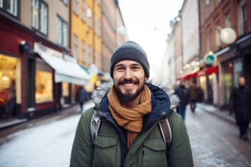 Wall Mural - Portrait of a young smiling man standing on the city street in Stockholm