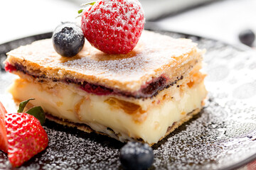 Wall Mural - A piece of Napoleon cake with poppy seeds and cherries