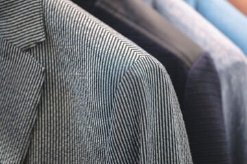 Racks with different men's suits in a men's clothing boutique.