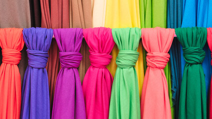 Poster - Mix colorful hanging vertical stripe textile, fabrics, cloths on the rack. Texture of multicolored fabrics close up.