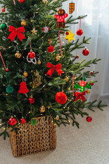 Wall Mural - Christmas tree in a wicker basket decorated  red and gold decorations, bows and toys. Merry Christmas and Happy Holidays!