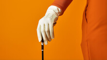 Man Hand In White Glove Holding Golf Club On Orange Background