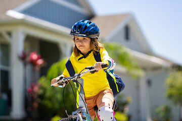 Canvas Print - Child on bicycle. Boy in a helmet riding bike. Little cute caucasian boy in safety helmet riding bike in city park. Child first bike. Kid outdoors summer activities. Kid on bicycle. Boy ride a bike.