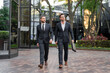 © Volodymyr - Business people discuss a project walkind on city. Two young businessmen walk outdoors city looking cityscape. Outdoor meeting of two business partners. Businessman in suits walkind outdoors.