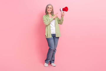 Full length photo of cheerful senior woman wear trendy clothes arm demonstrate bullhorn sale discount isolated on pink color background