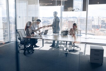 Wall Mural - Creative business people working on project in modern office with panoramic view. Teamwork concept