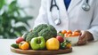 © Justlight - closeup shot captures the hands of veteran oncologist, explaining to patient using model where she points on the canceraffected area. On the desk, an array of fruits and vegetables implies