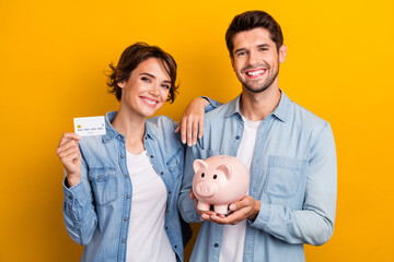 Photo of positive married couple save money use credit bank card isolated shine color background