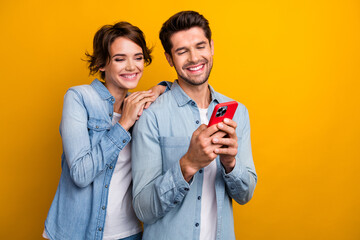 Photo of positive millennial couple lady guy using gadget online shopping isolated on shine color background