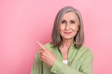 Sticker - Portrait of attractive pensioner woman wear khaki shirt ceo director pointing finger empty space novelty isolated on pink color background