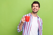 © deagreez - Photo of young dreamy young friendly guy wearing striped shirt hold cup hot coffee aroma good morning isolated on green color background