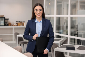 Happy real estate agent with leather portfolio in office