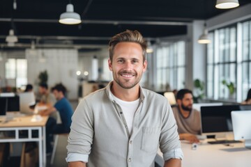 smiling portrait of a happy young caucasian man working for a modern startup company in a business o