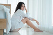 © kelvn - Asian young woman sitting sad beside the bed in bedroom. Woman having a relationship and mental health problem or depression syndrome.