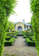House and green buxus labyrinths in summer ornamental garden