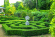Green buxus labyrinths  and decorative greek urn in spring park