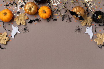 Wall Mural - Halloween holiday background with party decorations from pumpkins, bats, spider web and ghosts top view. Happy halloween greeting card flat lay style..