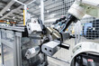 © Westend61 - White robotic arm with machinery in factory