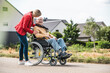 © Westend61 - Woman talking with elderly man sitting in wheelchair