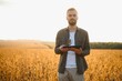 © Serhii - Portrait of farmer standing in soybean field at sunset.