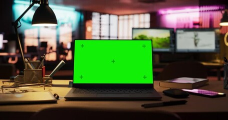 Leinwandbilder - Zoom in Shot of Laptop Computer Standing on a Wooden Desk with a Green Screen Chromakey Mock Up Display. Creative Office Working Station for Game Developer and Graphic Designer in Creative Agency