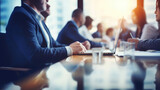 Fototapeta  - Panoramic view of business meeting in boardroom. Focus on office table and blurred people on backdrop.