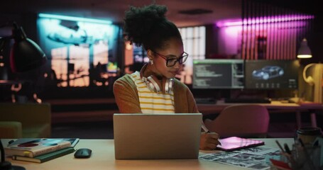 Aufkleber - Black Female Specialist is Writing Business Strategy, Using Digital Tablet to Take Notes in Creative Office Environment. Young Project Manager with Headphones Working on Laptop Computer